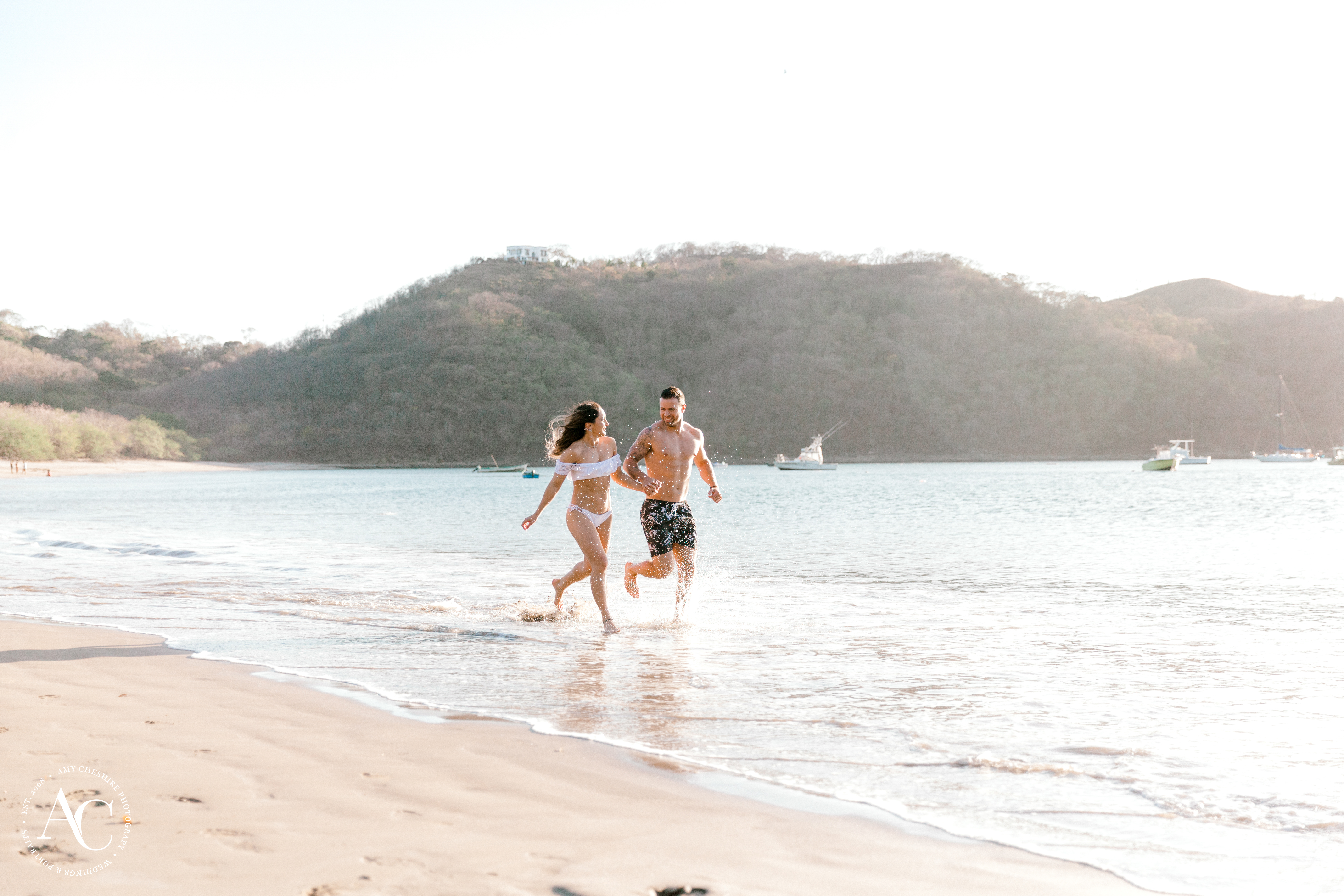engagement session of couple running on beach